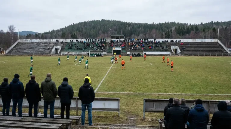 Piccolo stadio di calcio di un campionato minore europeo con tribune parzialmente occupate