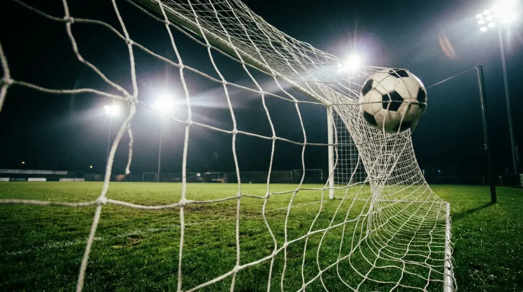 Pallone da calcio che entra in rete visto da dietro la porta